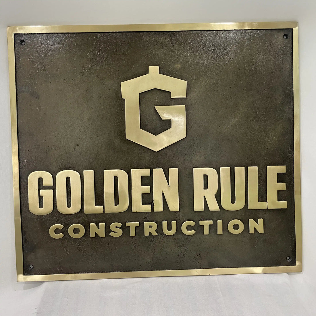 Custom bronze plaque with personalized engraving and antique bronze finish mounted on a stone wall