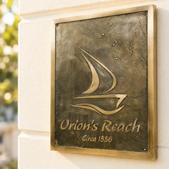 Angled left-side view of custom bronze sailboat plaque with antique brass border