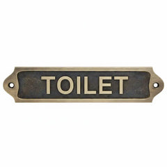 Antique brass door sign with 'TOILET' text on a white background