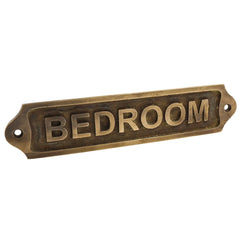 Antique brass 'BEDROOM' door sign on a white background