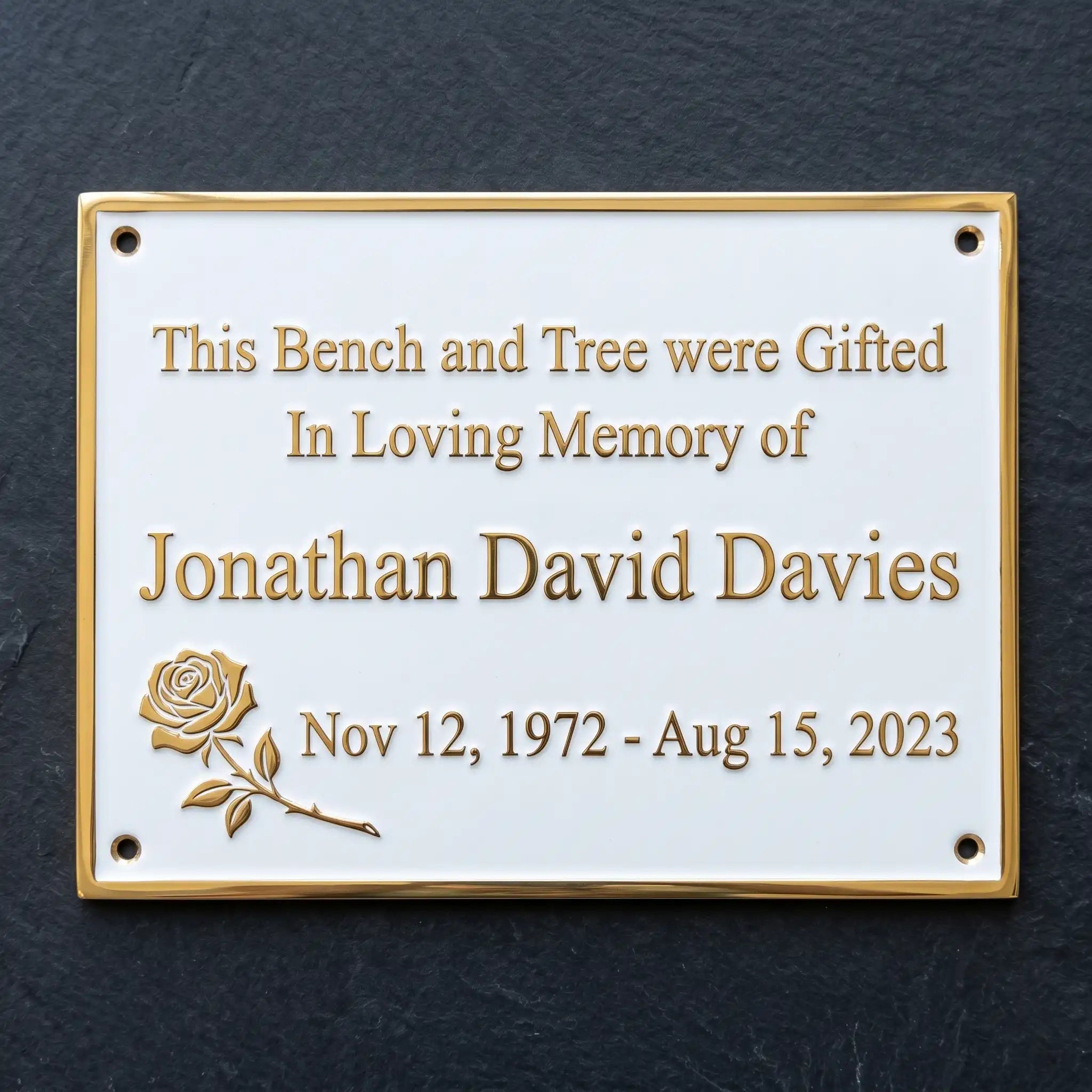 Memorial plaque with engraved text on a dark background