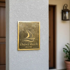 Brass plaque with Custom logo, name and year on a textured wall.
