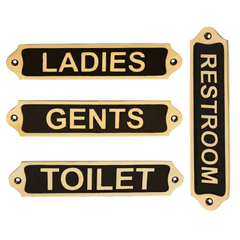 A set of four brass plaques with black text, indicating the locations for ladies, gents, and toilet in a home or commercial setting.