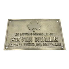 Memorial plaque with a shamrock symbol and text on a white background