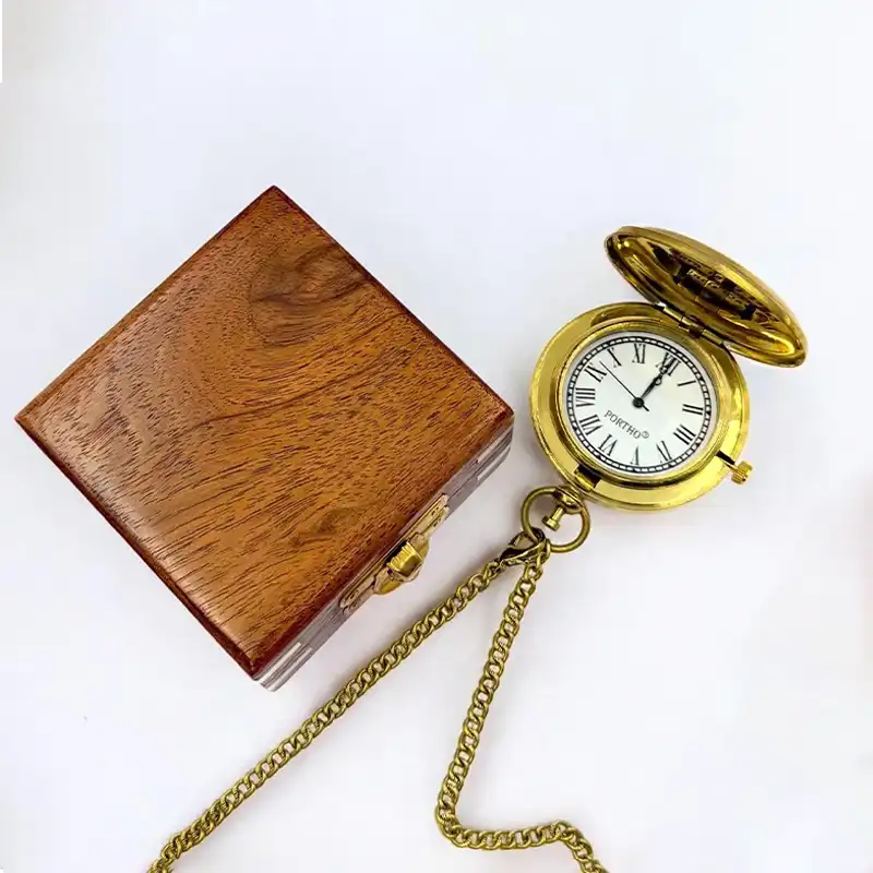 Gold pocket watch with chain and wooden box on a white background