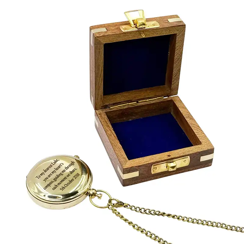 Wooden box with a gold lid and a gold necklace with a pendant on a white background