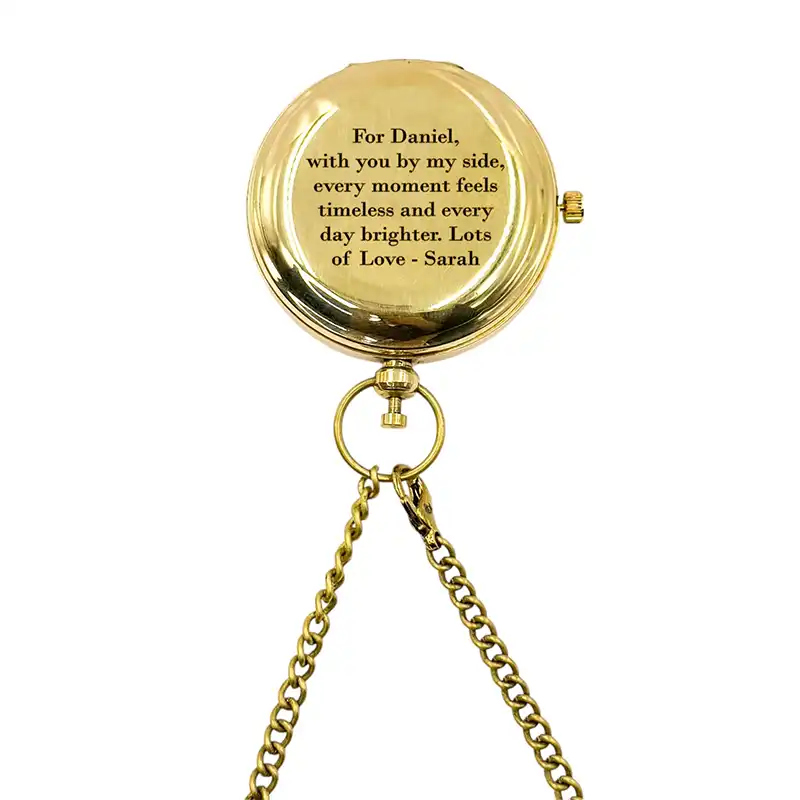 Gold pocket watch with engraved message on a white background