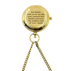 Gold pocket watch with engraved message on a white background