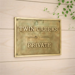 Brass finish brass address plate engraved | Gold plaque with text on a wooden background