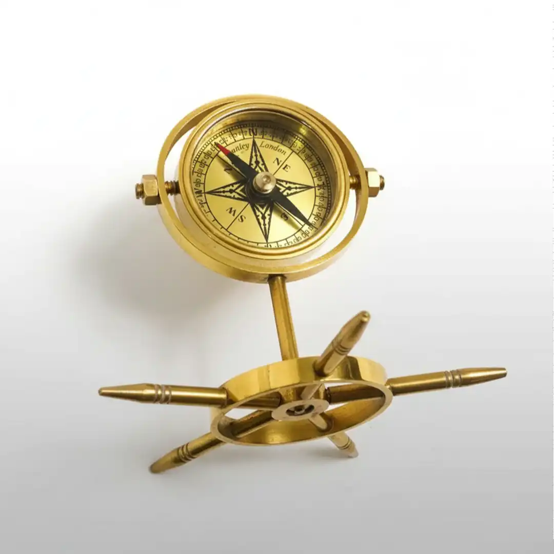 Brass Gimbal compass with decorative elements on a white background
