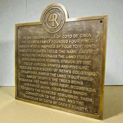 Bronze plaque with engraved text and Four Pines Ranch logo on a white background