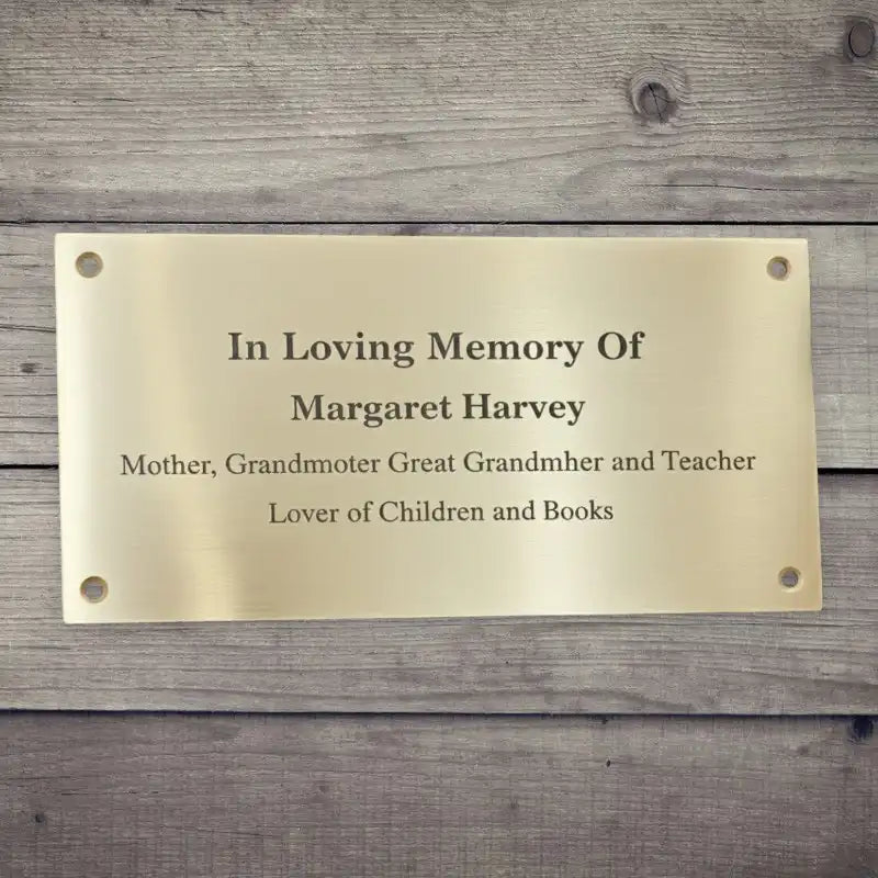 Brass plaque with engraved text on a wooden background