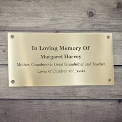 Brass plaque with engraved text on a wooden background