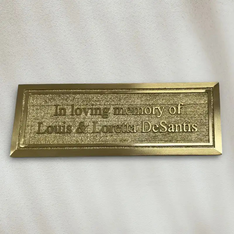 Brass plaque with engraved text on a white background