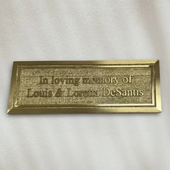 Brass plaque with engraved text on a white background
