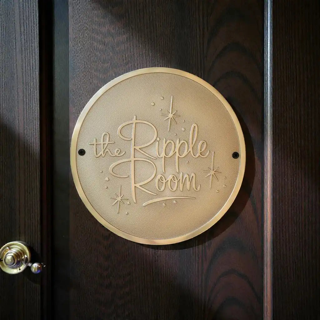 Round brass sign with 'the Ripple Room' on a wooden door, Custom brass sign