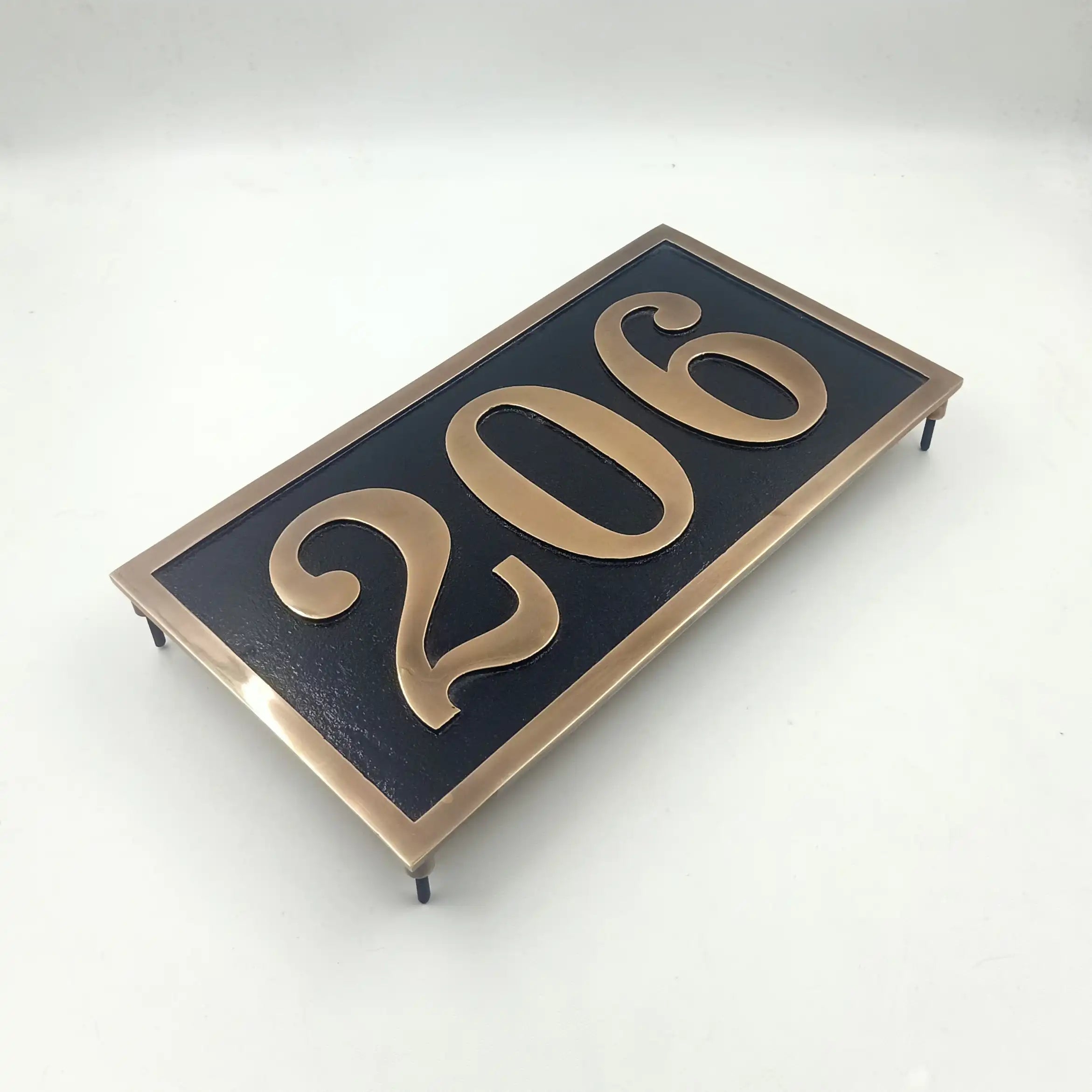 Rectangular address sign with '206' in gold on a black background