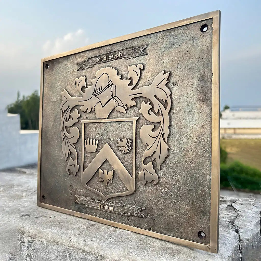 Bronze plaque with a classic design with a crest design on a stone surface outdoors.