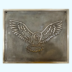 Heritage-style bronze metal plaque with an embossed owl design on a textured background