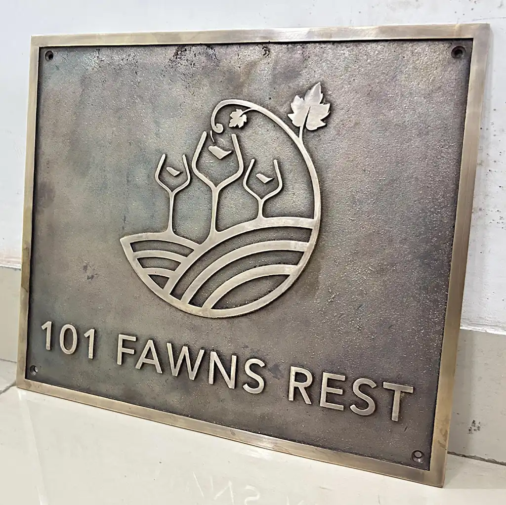 Personalized bronze vintage plaque, Metal plaque with '101 Fawns Rest' and decorative emblem on a white background
