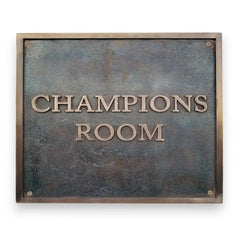 address sign with 'Champions Room' text on a textured metal background, custom bronze plaque for home