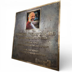 Plaque honoring Matthew Thompson, MD with a photo and text on a white background