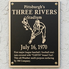 Plaque commemorating Pittsburgh's Three Rivers Stadium with a baseball player illustration and text.