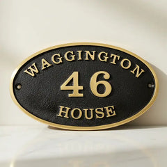 Bronze address plaques, oval house number sign on a white background