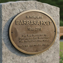 Memorial plaque honoring someone on a stone pedestal with a blurred background, Bronze memorial plaque