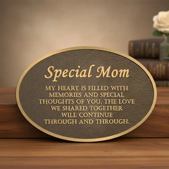 Bronze memorial plaques in an oval shape on a wooden surface