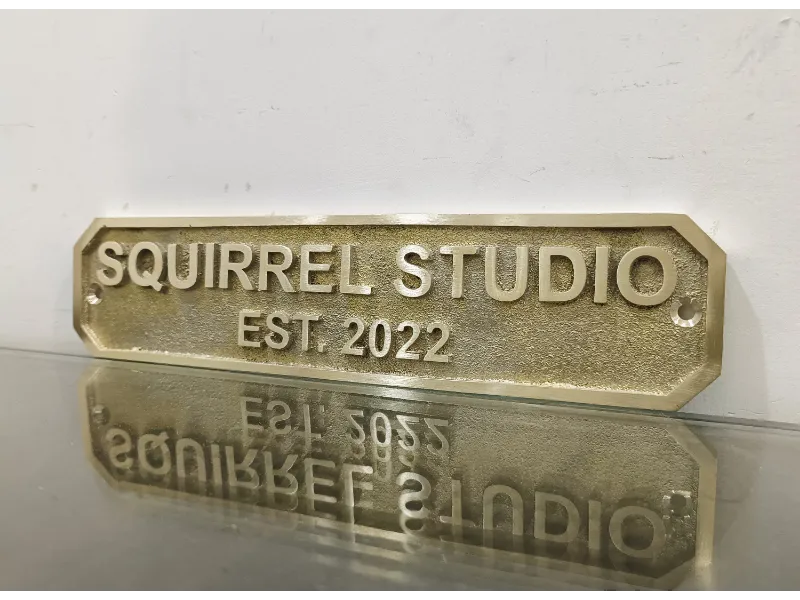 Personalized brass address sign mounted on front wall of home entrance