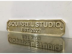 Personalized brass address sign mounted on front wall of home entrance