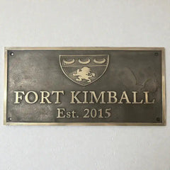 Bronze plaque with text and logo on a white wall | Bronze address plaque for house