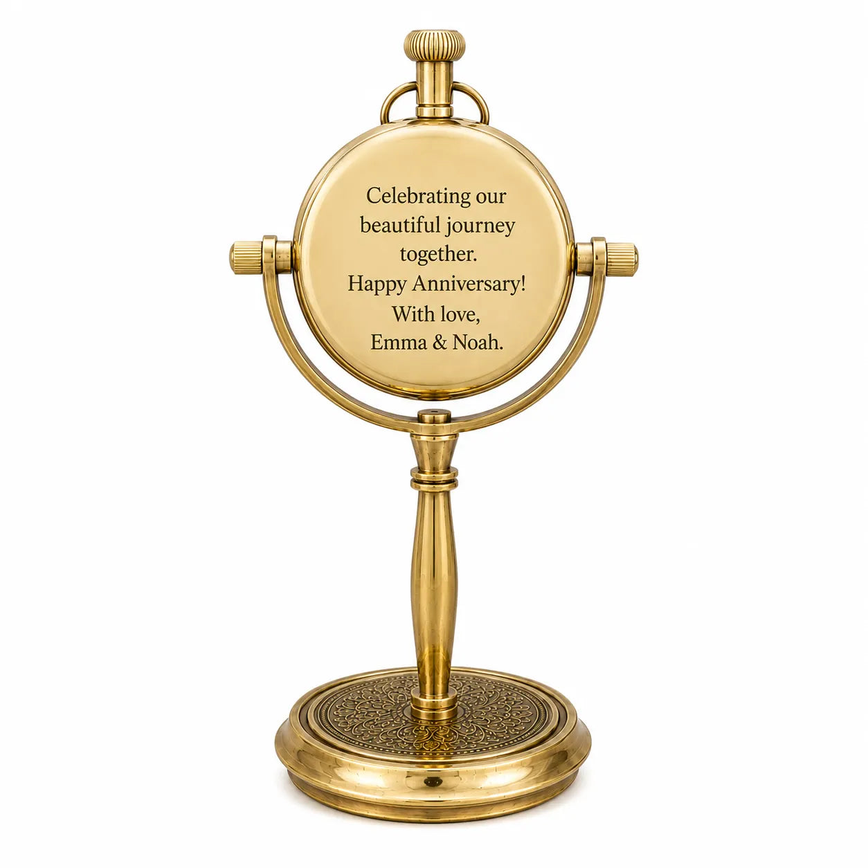 A gold-finished tabletop vanity mirror with a round engraved plaque on the front that reads, 'Celebrating our beautiful journey together. Happy Anniversary! With love, Emma & Noah.