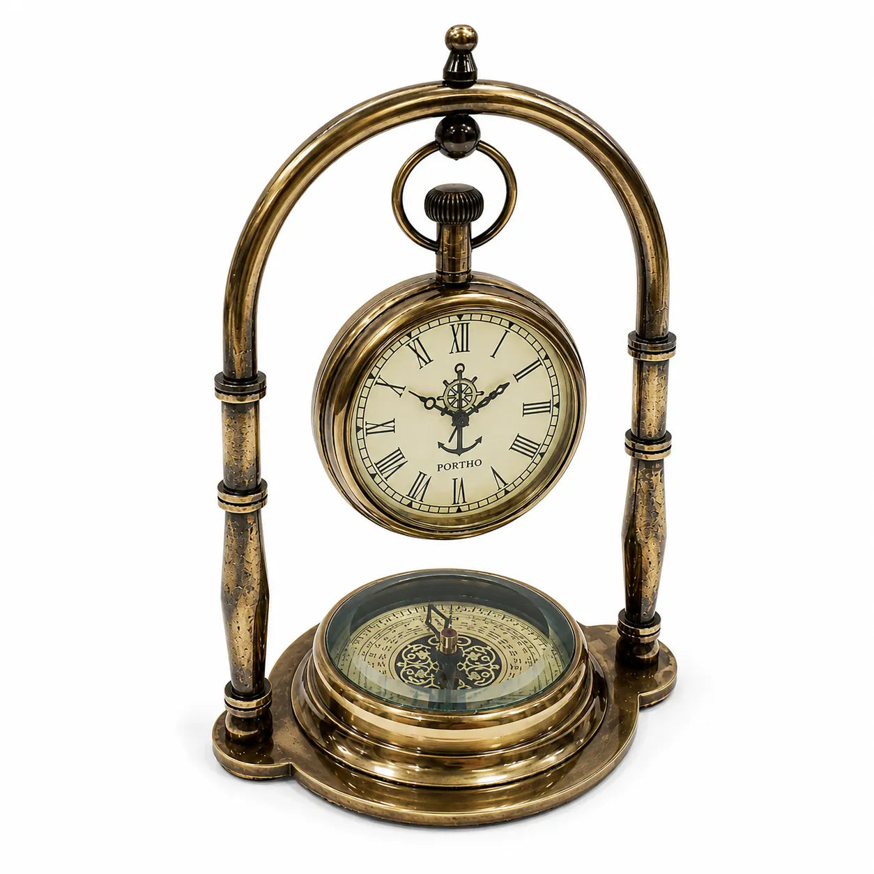 An antique-style brass mantel clock featuring a suspended pocket-watch face with Roman numerals and a compass base, photographed on a white background.
