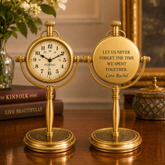 Two matching gold brass-style tabletop clocks on a polished wooden surface. One clock face is visible and reads 'FORTH' at 12 o'clock.