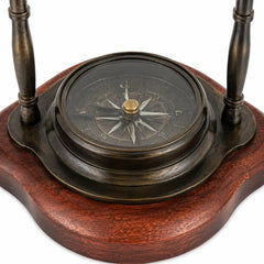 Close-up of glass-covered directional compass set in wooden base