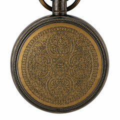 Close-up of decorative engraved back of antique brass hanging clock
