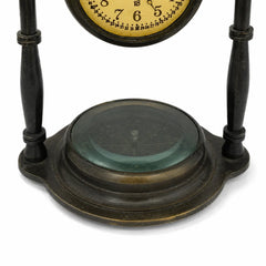 Close-up of glass-covered compass base on antique brass desk clock