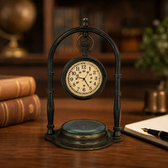 Antique brass desk clock with compass displayed on wooden office desk