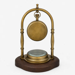 Full rear view of brass desk clock with plain clock back and compass base