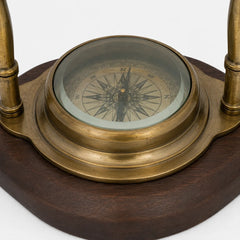 Close-up of glass-covered directional compass in antique brass base