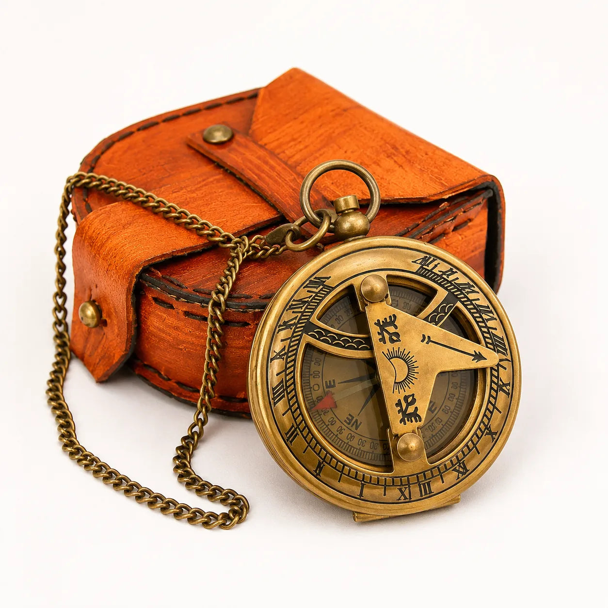 An antique brass pocket compass with a chain, displayed in front of its brown leather case on a white background.