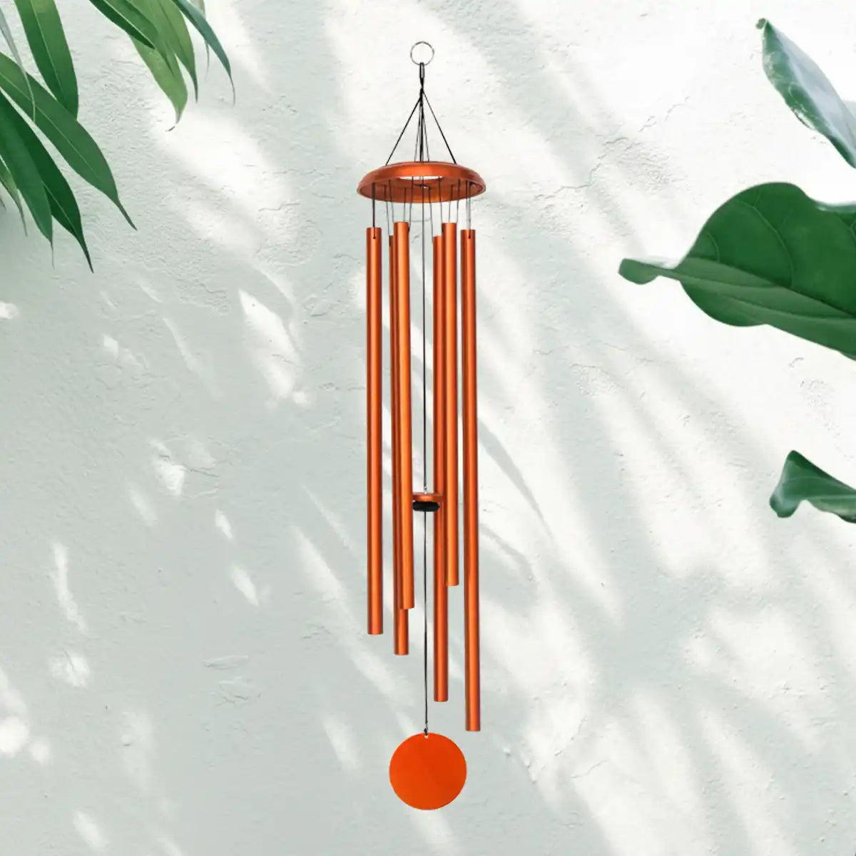 Copper Corinthian Bells Wind Chime with green leaves and white background