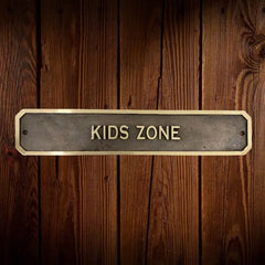 Brass Door sign with 'KIDS ZONE' text on a wooden background