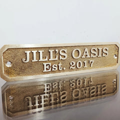 Front view of custom brass address sign with engraved house number and name