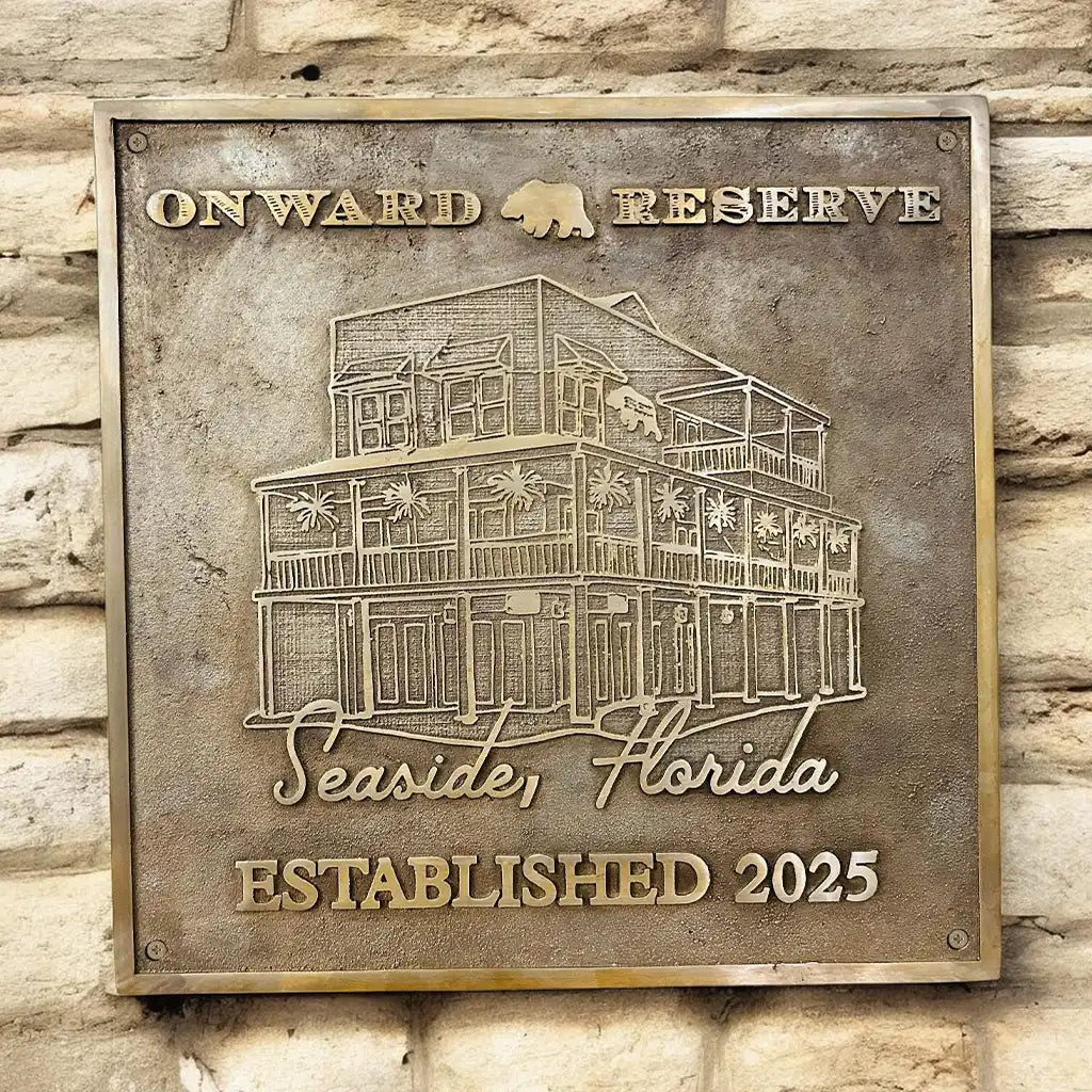 Bronze plaque with 'Onward Reserve' and building illustration on a stone wall background