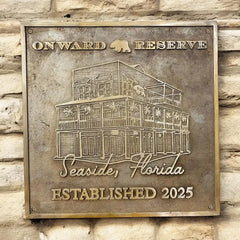 Bronze plaque with 'Onward Reserve' and building illustration on a stone wall background