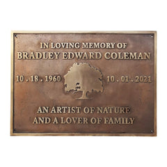 Bronze/brass memorial plaque with engraved text and tree design on a white background