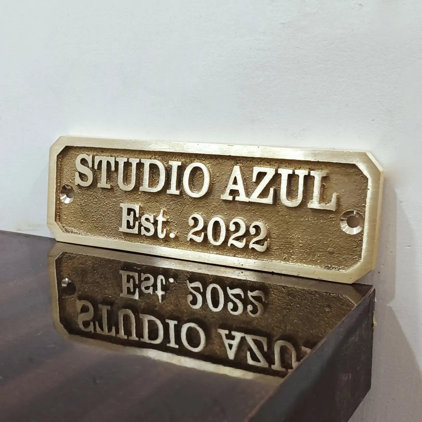 Brass plaque with custom text on a reflective surface.